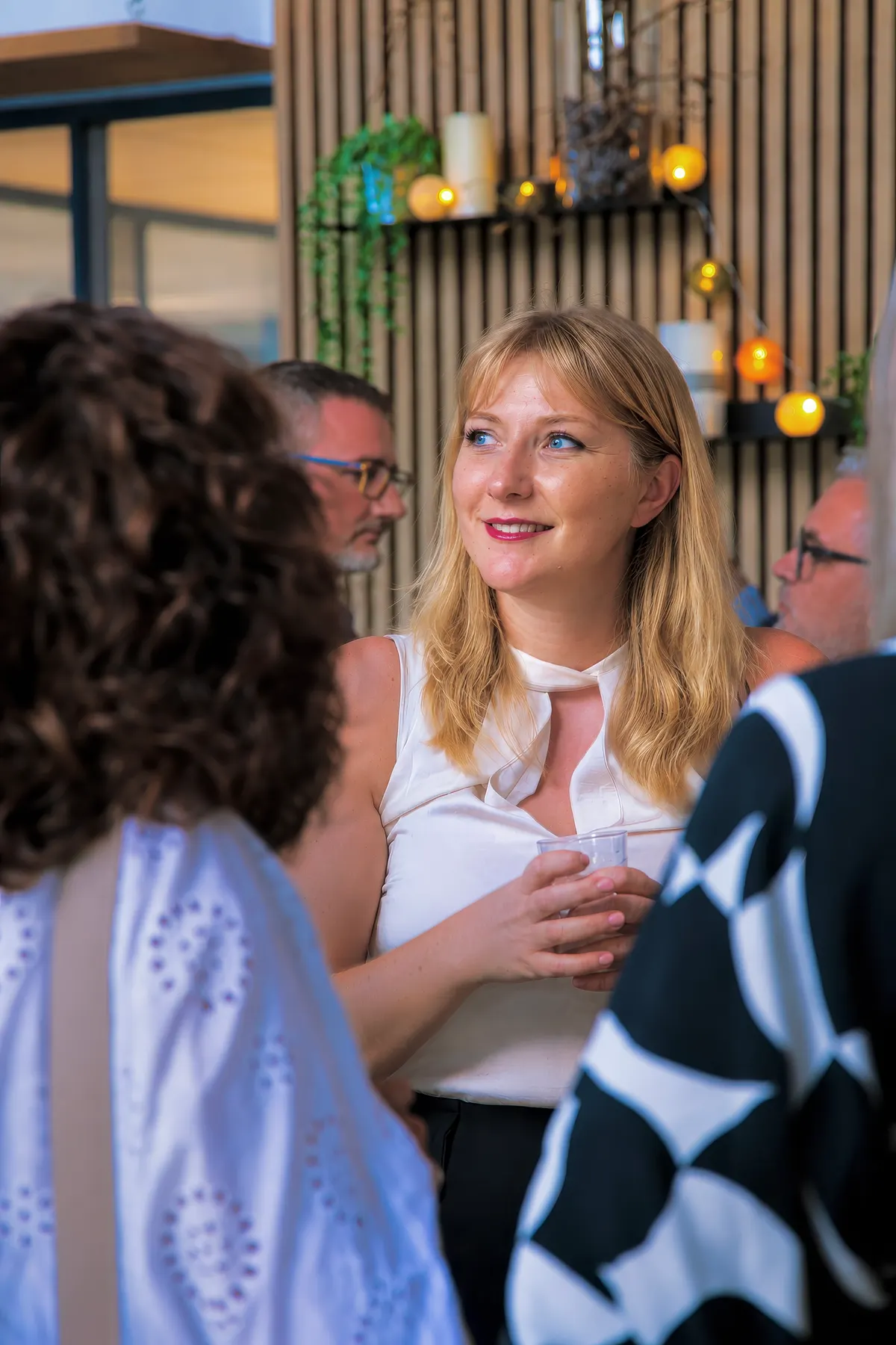 Invitée, verre à la main, lors d'un événement Ô6Bis